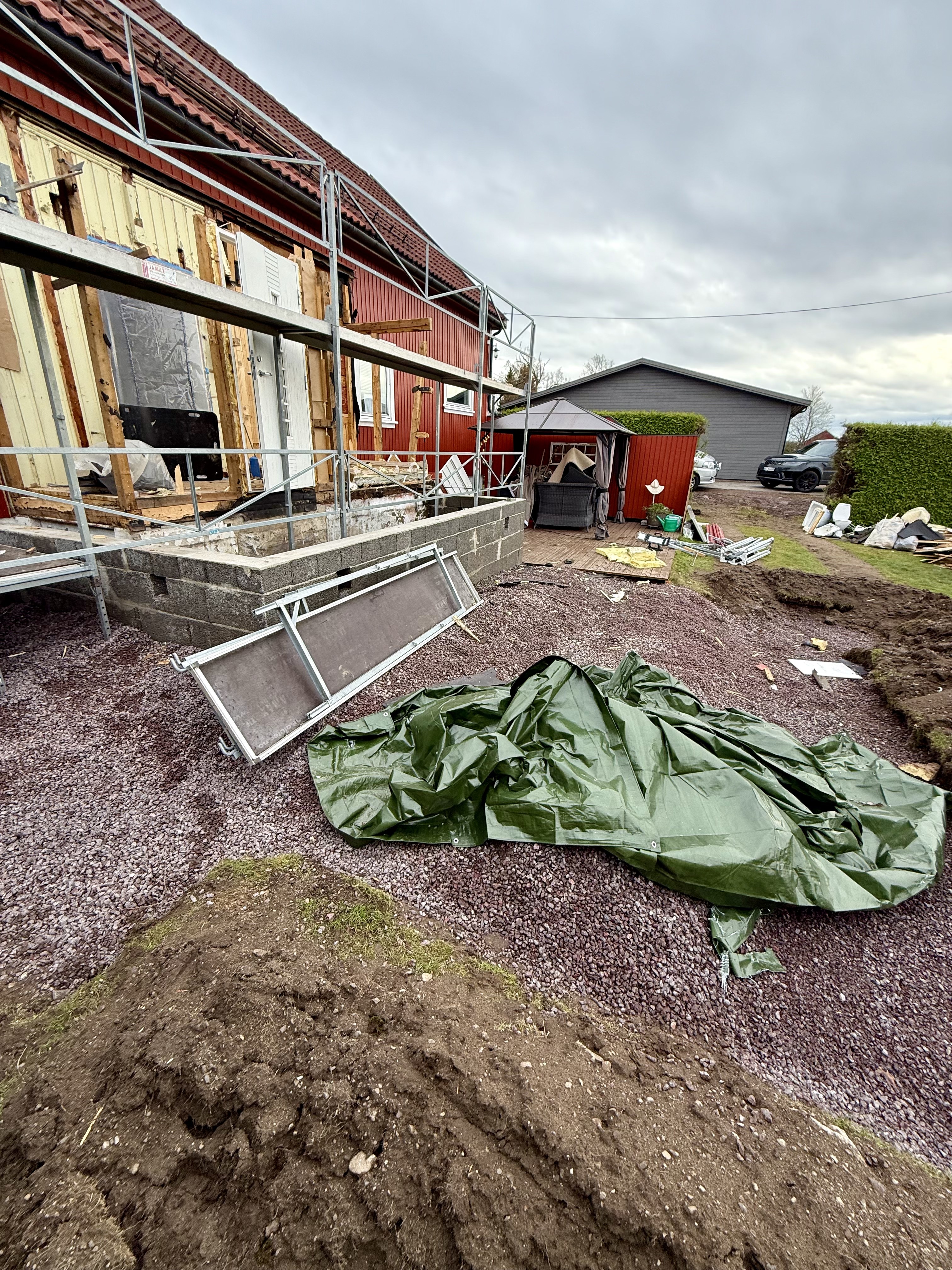 Tilbygg på Borre under rehabilitering med stillas, åpnet fasade og grunnarbeid