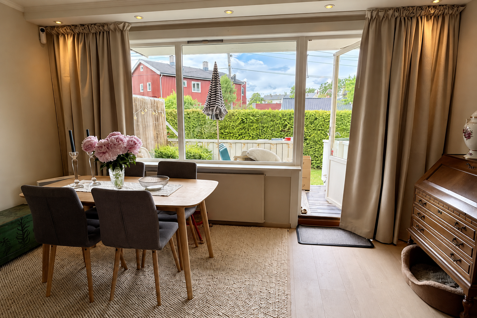 Stue med beige gardiner rundt et stort vindu